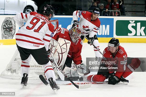 Steve Stamkos of Canada tries to score against goalkeeper Tobias Stephan and Mathias Seger of Switzerland during the IIHF World Championship group C...