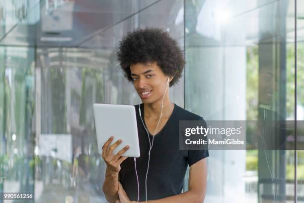 young man working on tablet pc - mamigibbs stock pictures, royalty-free photos & images