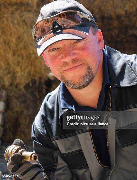 July 2018, Germany, Potsdam: Demolition expert Mike Schwitzke has deactivated the 250 kg second world war bomb and is holding the detonator in his...