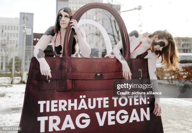 Two activists of the environmental organisation "Peta" demonstrate with an oversized hand bag reading "Animal Skins Kill: wear vegan" during the...