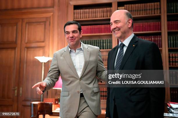 Greek prime minister Alexis Tsipras welcomes EU Economic Affairs Commissioner Pierre Moscovici prior to their talks in Athens on July 3, 2018.