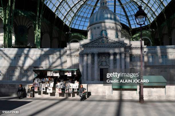 German fashion designer Karl Lagerfeld's godson Hudson Kroenig sits next to a replica of Parisian open-air book stalls and the French Institute...