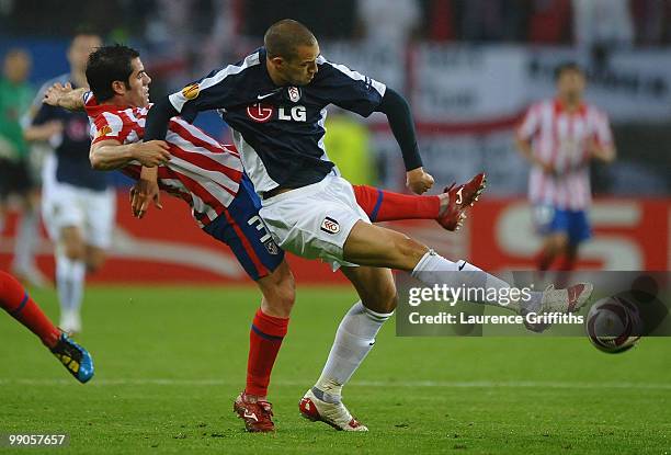 Antonio Lopez of Atletico Madrid challenges Bobby Zamora of Fulham during the UEFA Europa League final match between Atletico Madrid and Fulham at...