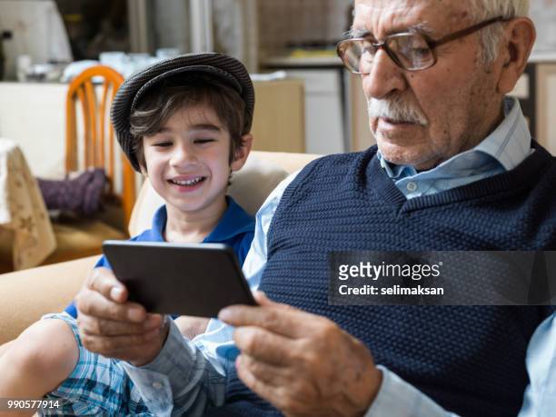 曽祖父と孫の携帯電話 i̇n リビング ルームを見ての肖像画 - great grandfather ストックフォトと画像