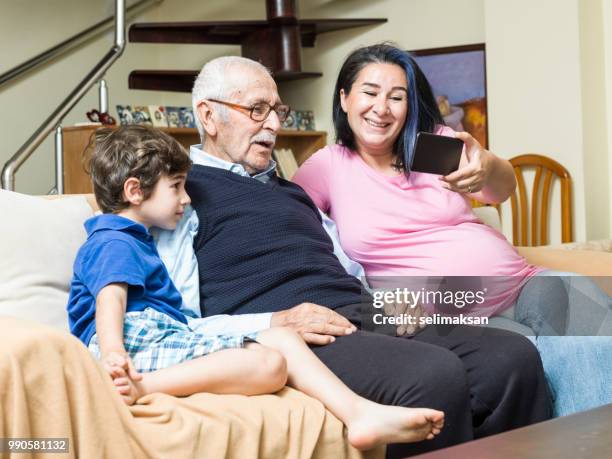 ritratto di famiglia di tre generazioni in salotto - selimaksan foto e immagini stock