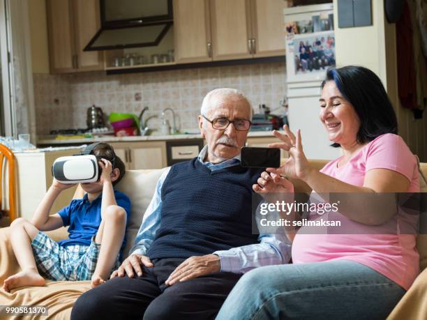 ritratto di famiglia di tre generazioni in salotto - selimaksan foto e immagini stock