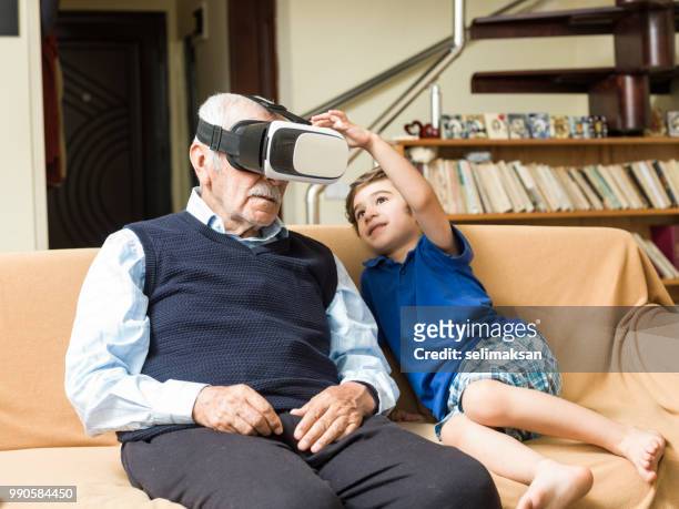 遊び心のある素晴らしい孫と vr のヘッドセットを使用して年配の男性の肖像画 - great grandfather ストックフォトと画像