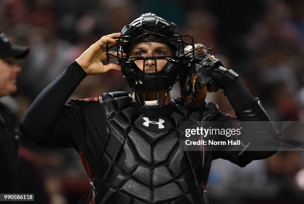 John Ryan Murphy of the Arizona Diamondbacks adjusts his mask while standing behind home plate against the San Francisco Giants at Chase Field on...