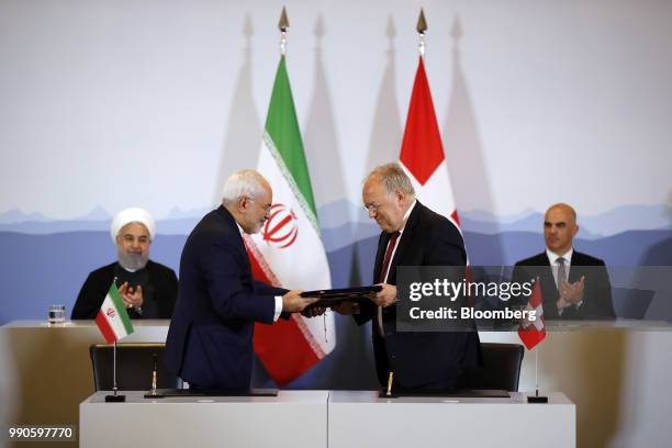 Hassan Rouhani, Iran's president, left, and Alain Berset, Switzerland's president, right, pause as Mohammad Javad Zarif, Iran's foreign secretary,...