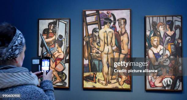February 2018, Germany, Potsdam: A journalist takes a picture of the triptych 'Schauspieler' by Max Beckmann at the Museum Barberini. From Saturday...