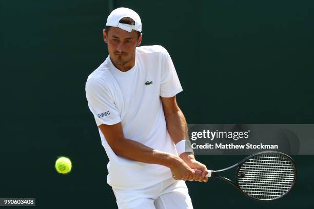 Bernard Tomic of Australia returns against Hubert Hurkac of Poland during their Men's Singles first round match on day two of the Wimbledon Lawn...