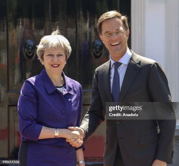 Dutch Prime Minister Mark Rutte shakes hands with his British counterpart Theresa May while they pose for a photo before a work lunch at the...