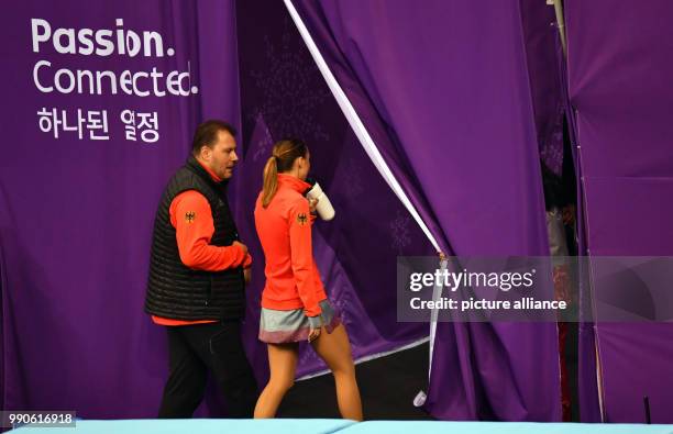 Germany's Nicole Schott and her coach Michael Huth leave the Gangneung Ice Arena after the women's figure skating singles in Gangneung, South Korea,...