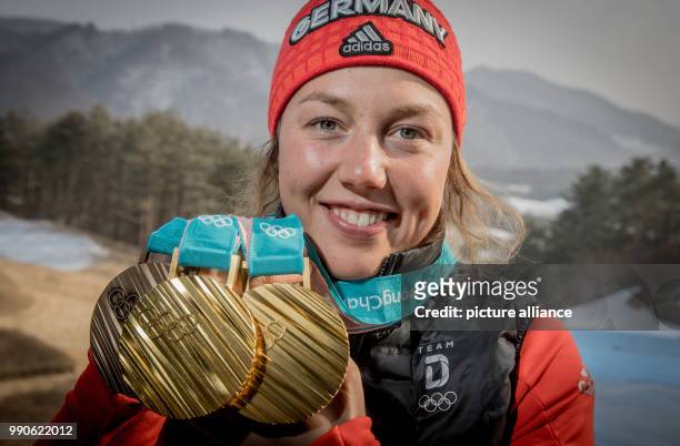 German biathlete Laura Dahlmeier holds up the medals she won at this year's Winter Olympics in Pyeongchang, South Korea, 23 February 2018. Dahlmeier...