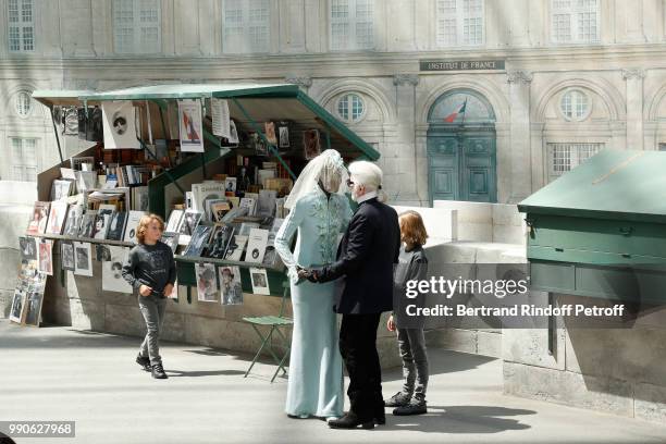 Model Adut Akech, Hudson Kroenig and Chanel Stylist Karl Lagerfeld acknowledge the applause of the audience at the end of the Chanel Haute Couture...