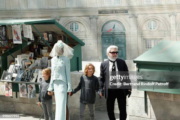 Model Adut Akech, Hudson Kroenig and Chanel Stylist Karl Lagerfeld acknowledge the applause of the audience at the end of the Chanel Haute Couture...