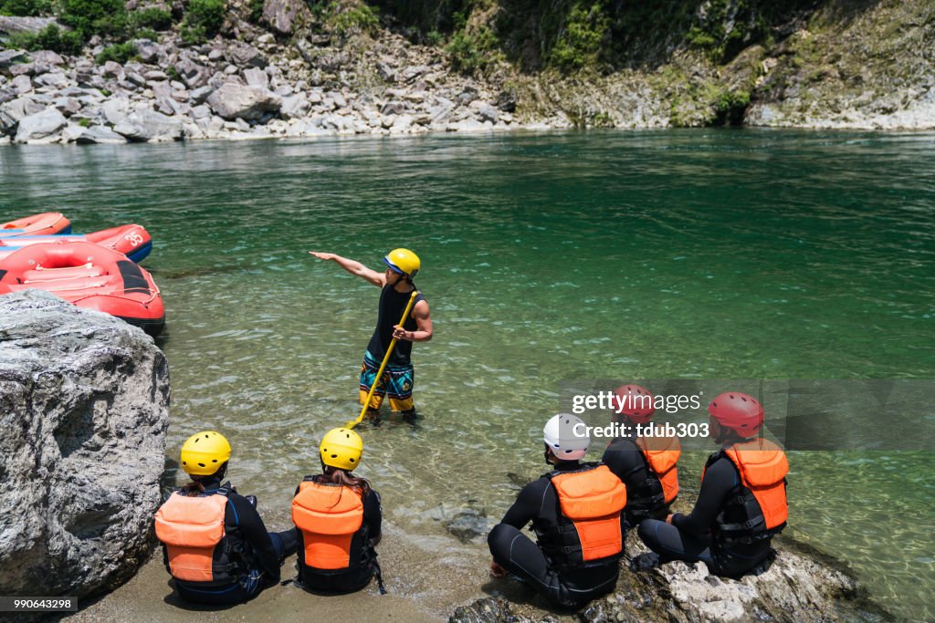 Small group of men and women preparing to go white water river rafting