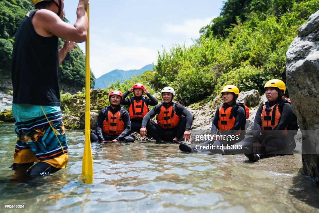 Small group of men and women preparing to go white water river rafting