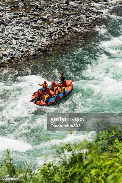 grupo de hombres y mujeres aguas blancas rafting en el río - rafting fotografías e imágenes de stock