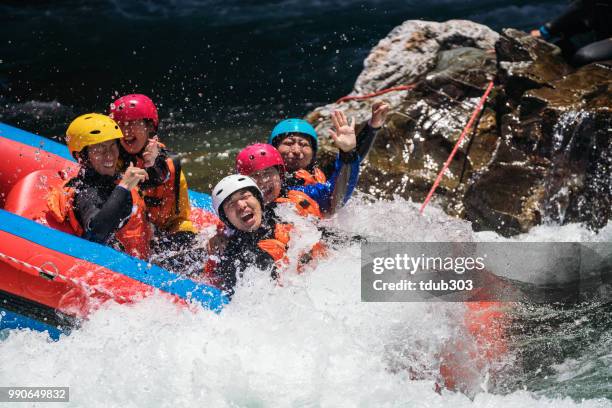 Group of men and women white water river rafting