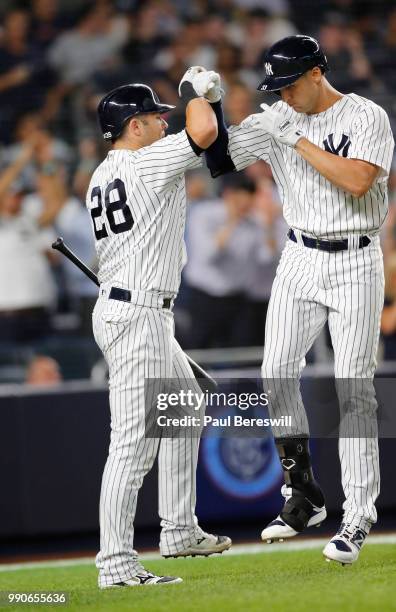 Austin Romine greets teammate Greg Bird of the New York Yankees after Bird hit his second home run of the game in the 8th inning in an MLB baseball...