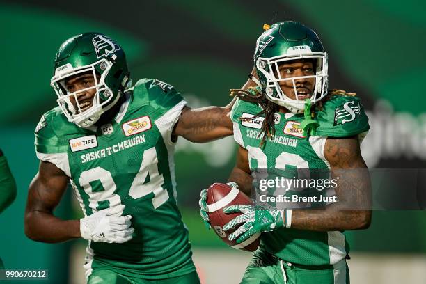 Jordan Williams-Lambert of the Saskatchewan Roughriders congratulates Naaman Roosevelt after a touchdown catch in the game between the Montreal...