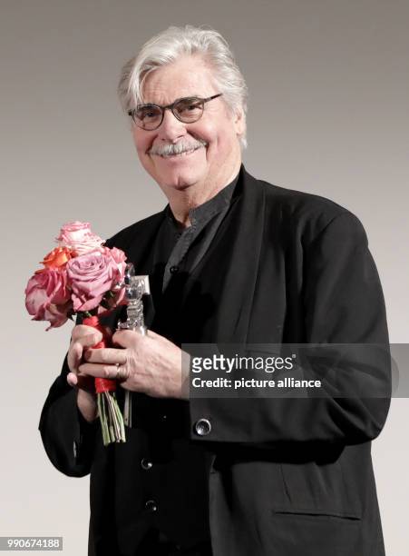 Febuary 2018, Germany, Berlin: Berlinale, Berlinale Kamera for Jiri Menzel: the actor Peter Simonischek accepts the Berlinale Kamera and a bouquet of...