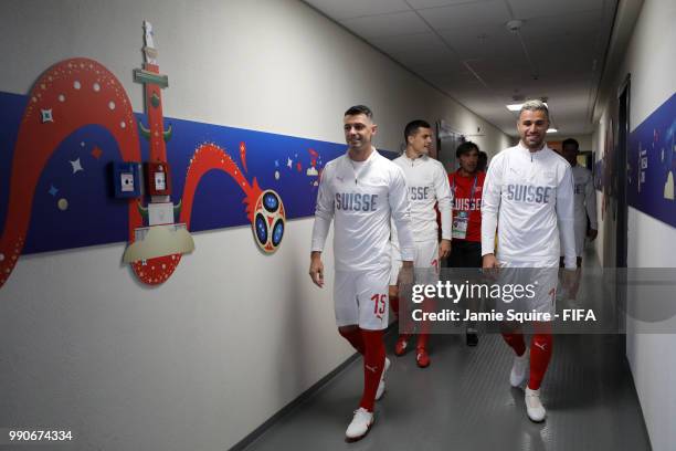 Blerim Dzemaili, Valon Behrami and Granit Xhaka of Switzerland walk in the tunnel prior to the 2018 FIFA World Cup Russia Round of 16 match between...