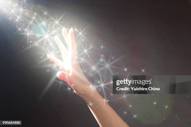 woman's hands reaching a glowing light - zeitstrahl stock-fotos und bilder