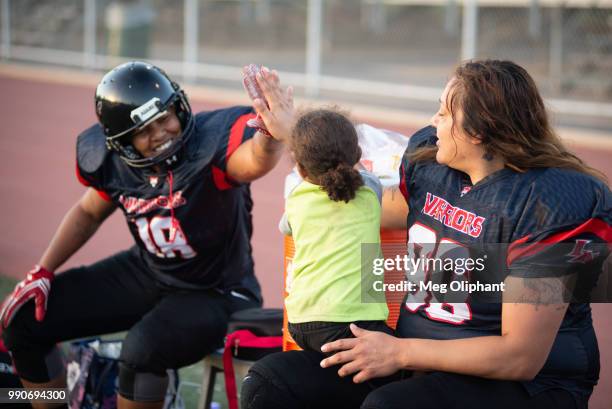 Jeanette Jimenez's son gives AJ Quinny of the LA Warriors a high-five from the sideline of the gamevagainst the Portland Fighting Shockwave at Rancho...