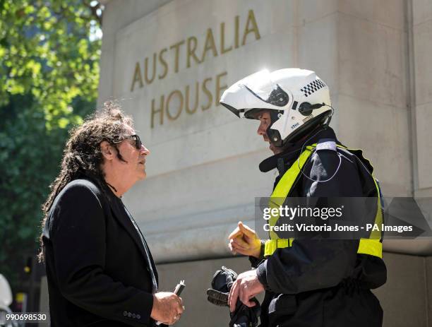 Julian Assange supporter, Ciaron O'Reilly talks with a police officer after being escorted out of the Australian High Commission office, where a...