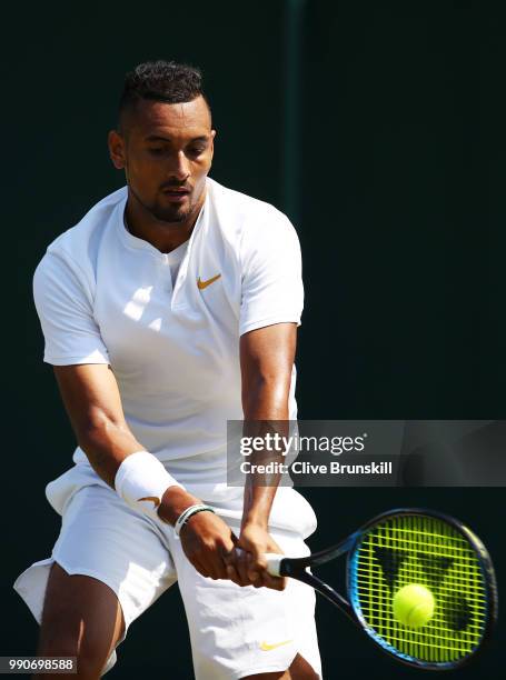 Nick Kyrgios of Australia plays a backhand during his Men's Singles first round match against Denis Istomin of Uzbekistan on day two of the Wimbledon...