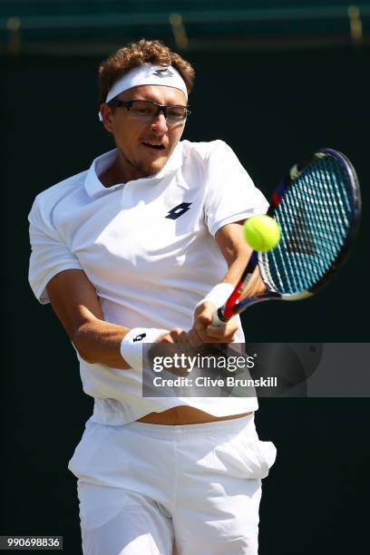 Denis Istomin of Uzbekistan plays a backhand during his Men's Singles first round match against Nick Kyrgios of Australia on day two of the Wimbledon...
