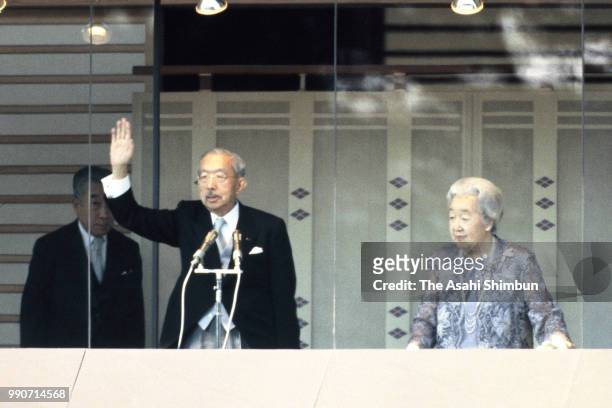 Emperor Hirohito and Empress Nagako wave to well-wishers from a balcony at a New Year celebration at the Imperial Palace on January 2, 1986 in Tokyo,...