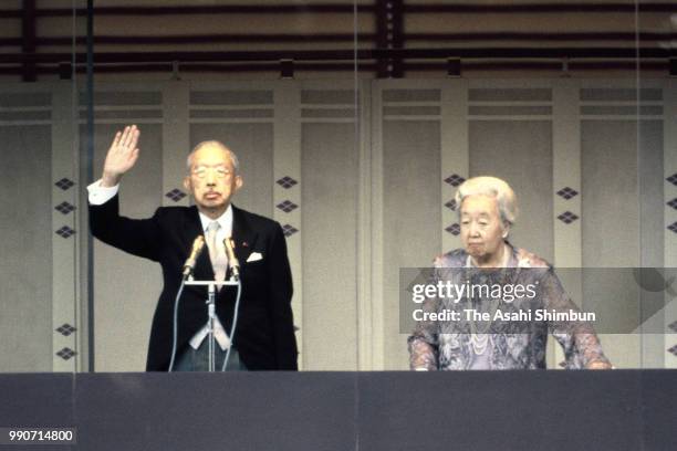 Emperor Hirohito and Empress Nagako wave to well-wishers from a balcony at a New Year celebration at the Imperial Palace on January 2, 1986 in Tokyo,...