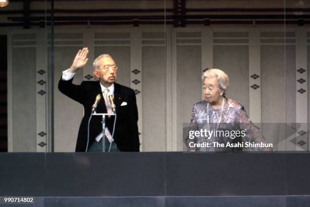 Emperor Hirohito and Empress Nagako wave to well-wishers from a balcony at a New Year celebration at the Imperial Palace on January 2, 1986 in Tokyo,...