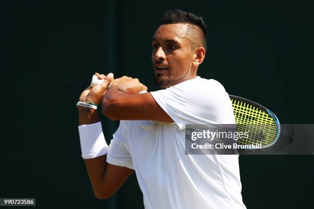 Nick Kyrgios of Australia returns against Denis Istomin of Uzbekistan during his Men's Singles first round match on day two of the Wimbledon Lawn...