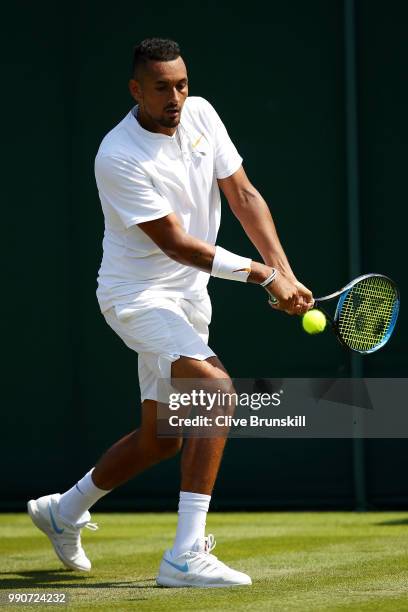 Nick Kyrgios of Australia returns against Denis Istomin of Uzbekistan during his Men's Singles first round match on day two of the Wimbledon Lawn...