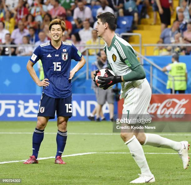 Thibaut Courtois of Belgium holds the ball near Yuya Osako of Japan during the first half of a World Cup round-of-16 match in Rostov-On-Don, Russia,...