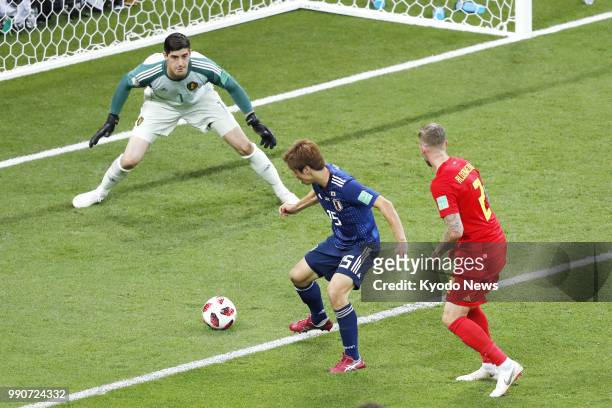 Belgium's goalkeeper Thibaut Courtois looks at Yuya Osako of Japan as he attempts to shoot during the first half of a World Cup round-of-16 match in...