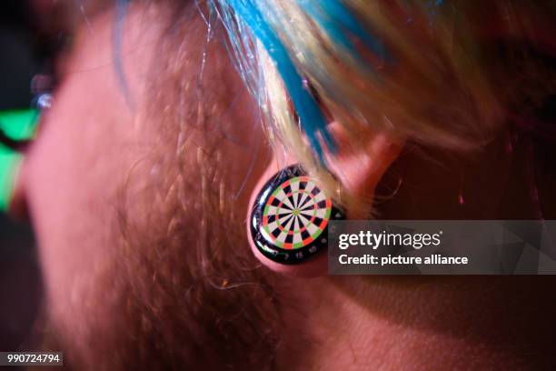 February 2018, Germany, Berlin: Darts: Premier League, 4th match day at Mercedes-Benz-Arena. A fan wears an earring in the shape of a dart board....