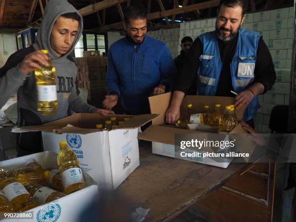 Men carry food sacks in an aliment distribution centre of UNRWA in Gaza, Palestinian Territories, 13 February 2018. UNRWA distributes basic aliments...