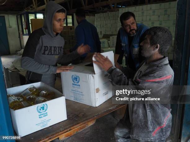 Men carry food sacks in an aliment distribution centre of UNRWA in Gaza, Palestinian Territories, 13 February 2018. UNRWA distributes basic aliments...