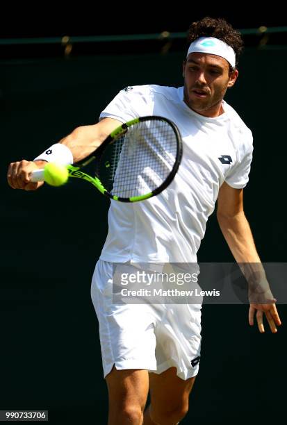 Marco Cecchinato of Italy returns against Alex De Minaur of Australia during their Men's Singles first round match on day two of the Wimbledon Lawn...