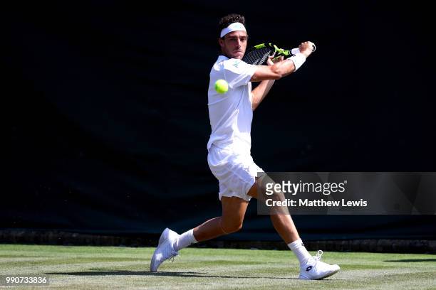 Marco Cecchinato of Italy returns against Alex De Minaur of Australia during their Men's Singles first round match on day two of the Wimbledon Lawn...