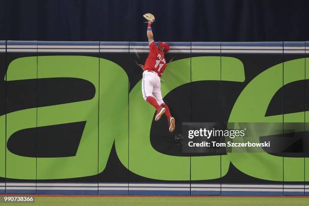 Kevin Pillar of the Toronto Blue Jays climbs the wall and catches a fly ball hit by Nicholas Castellanos of the Detroit Tigers in the ninth inning...