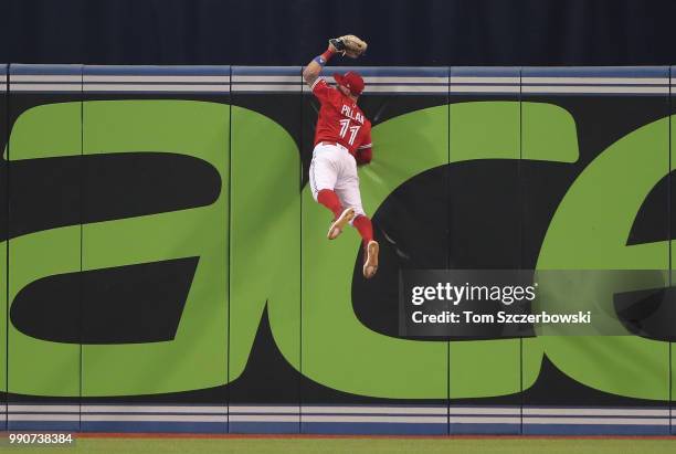 Kevin Pillar of the Toronto Blue Jays climbs the wall and catches a fly ball hit by Nicholas Castellanos of the Detroit Tigers in the ninth inning...