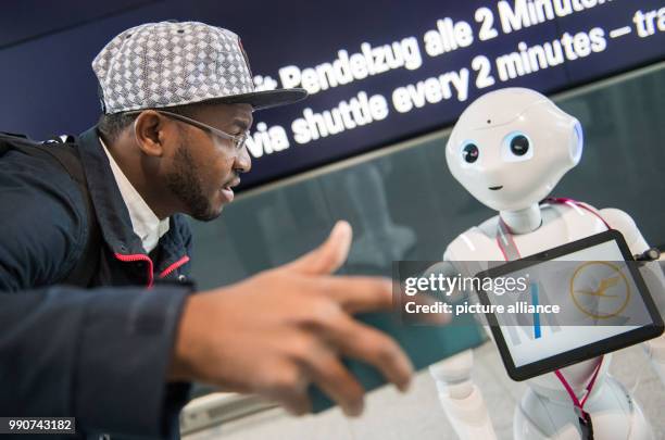 Robot Josie Pepper assists passenger Nadio Garrido from Angola at the airport in Munich, Germany, 20 February 2018. Pepper is a humanoid robot...