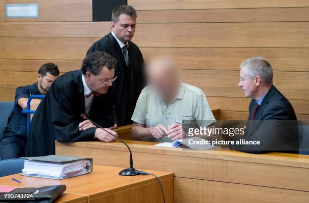July 2018, Traunstein, Germany: The 63 year old defendant who is charged for 2 murders sits before the hearing with an interpreter and his attorneys...