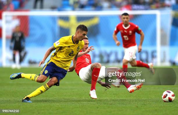 Josip Drmic of Switzerland is challenged by Mikael Lustig of Sweden during the 2018 FIFA World Cup Russia Round of 16 match between Sweden and...